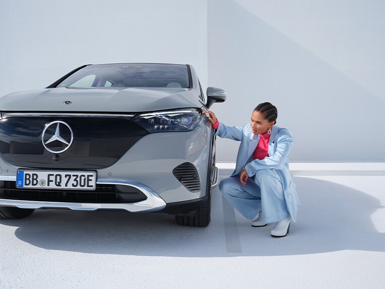 ผู้ชายคนหนึ่งอยู่ด้านหน้ารถยนต์ Mercedes-Benz