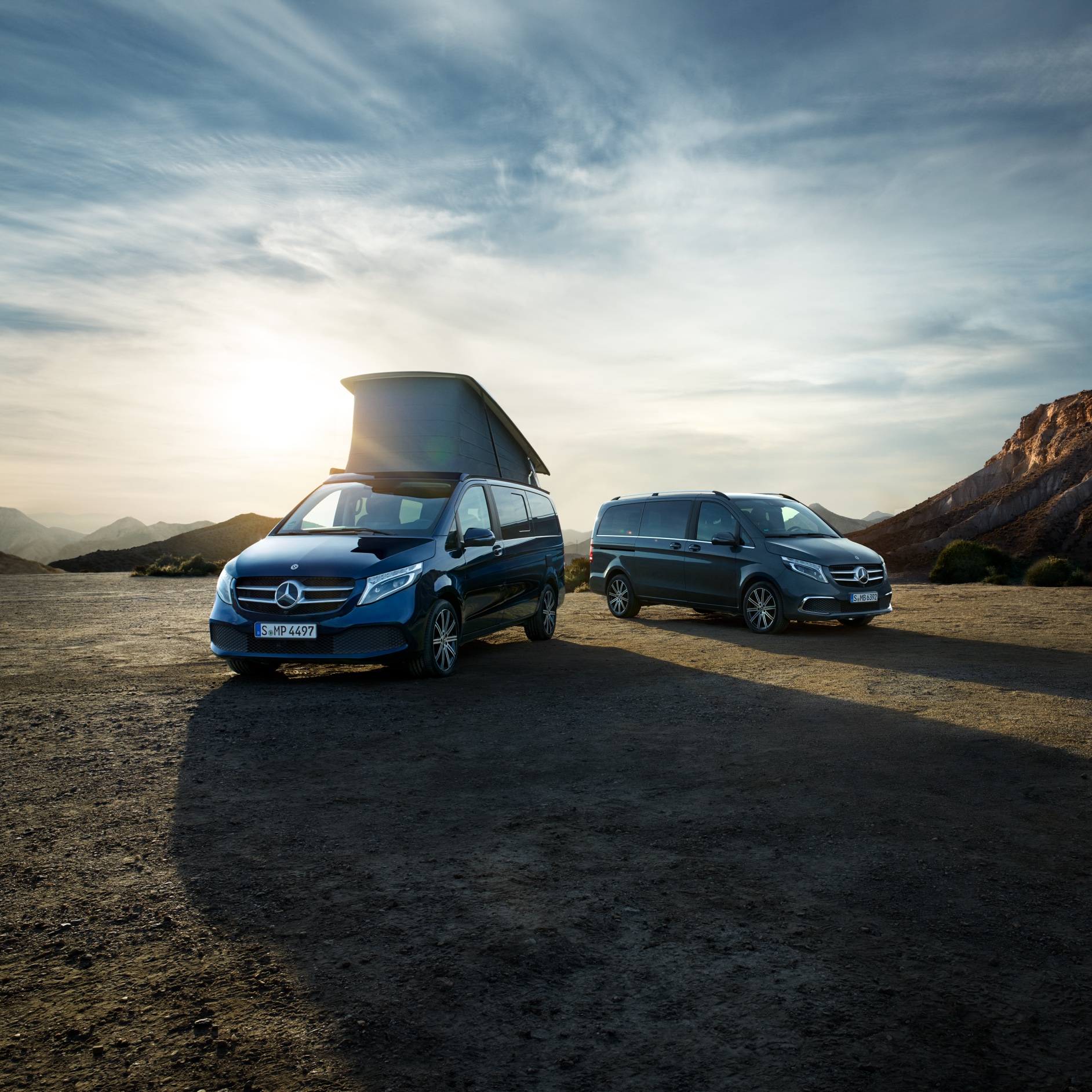 Vans and camper models | Mercedes-Benz The Marco Polo, a Mercedes-Benz camper van, and the Mercedes-Benz V-Class in the middle of a mountainous desert landscape.
