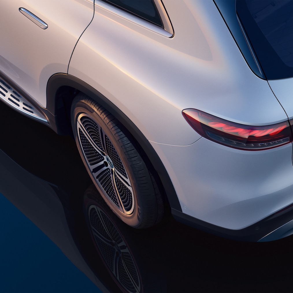 ภาพถ่ายจากด้านบน แสดงให้เห็นส่วนด้านหลังซ้ายของรถยนต์ SUV รุ่น EQS โดยมีล้อหลังที่หมุนเล็กน้อย