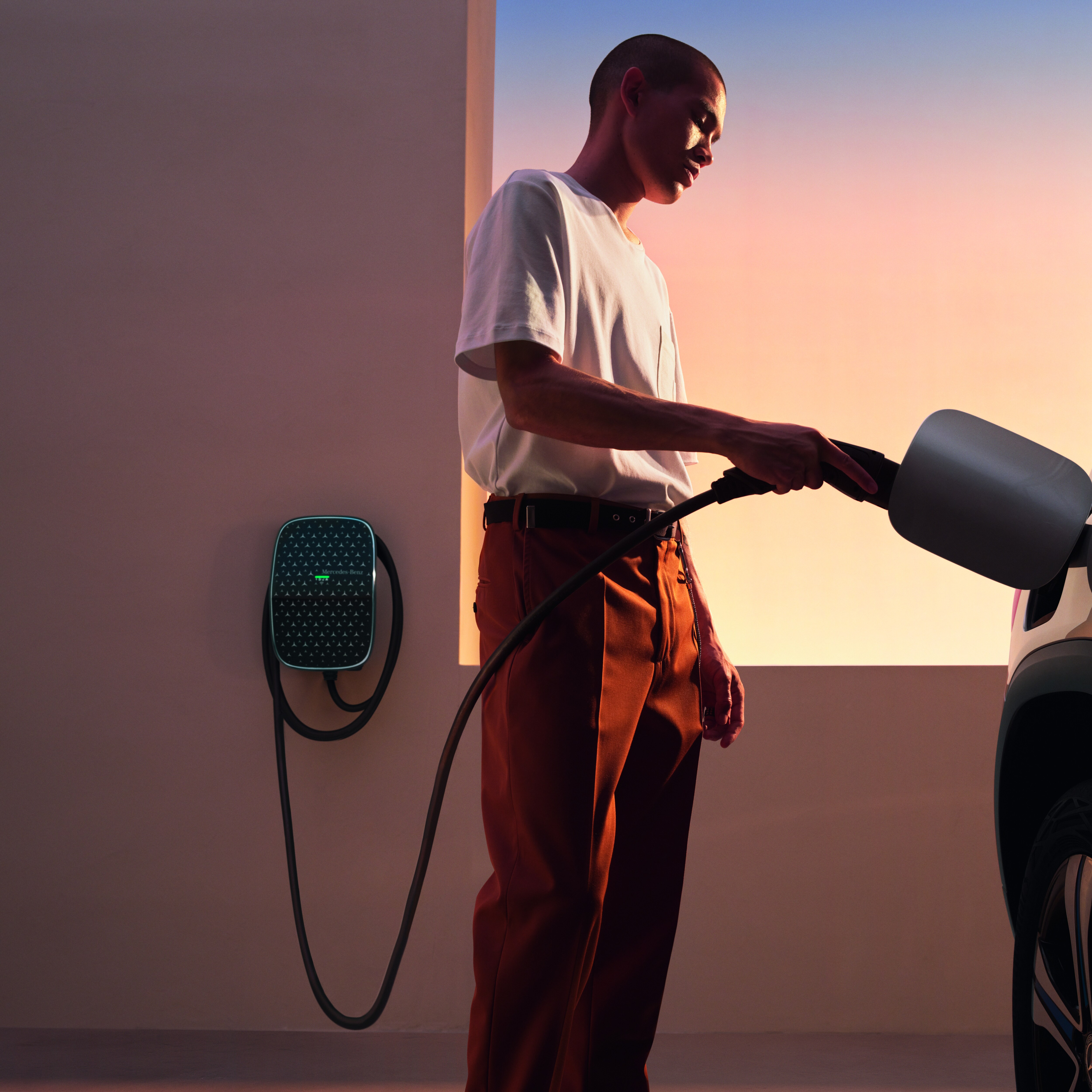 A man charging a Mercedes-EQ or Mercedes-Benz plug-in hybrid