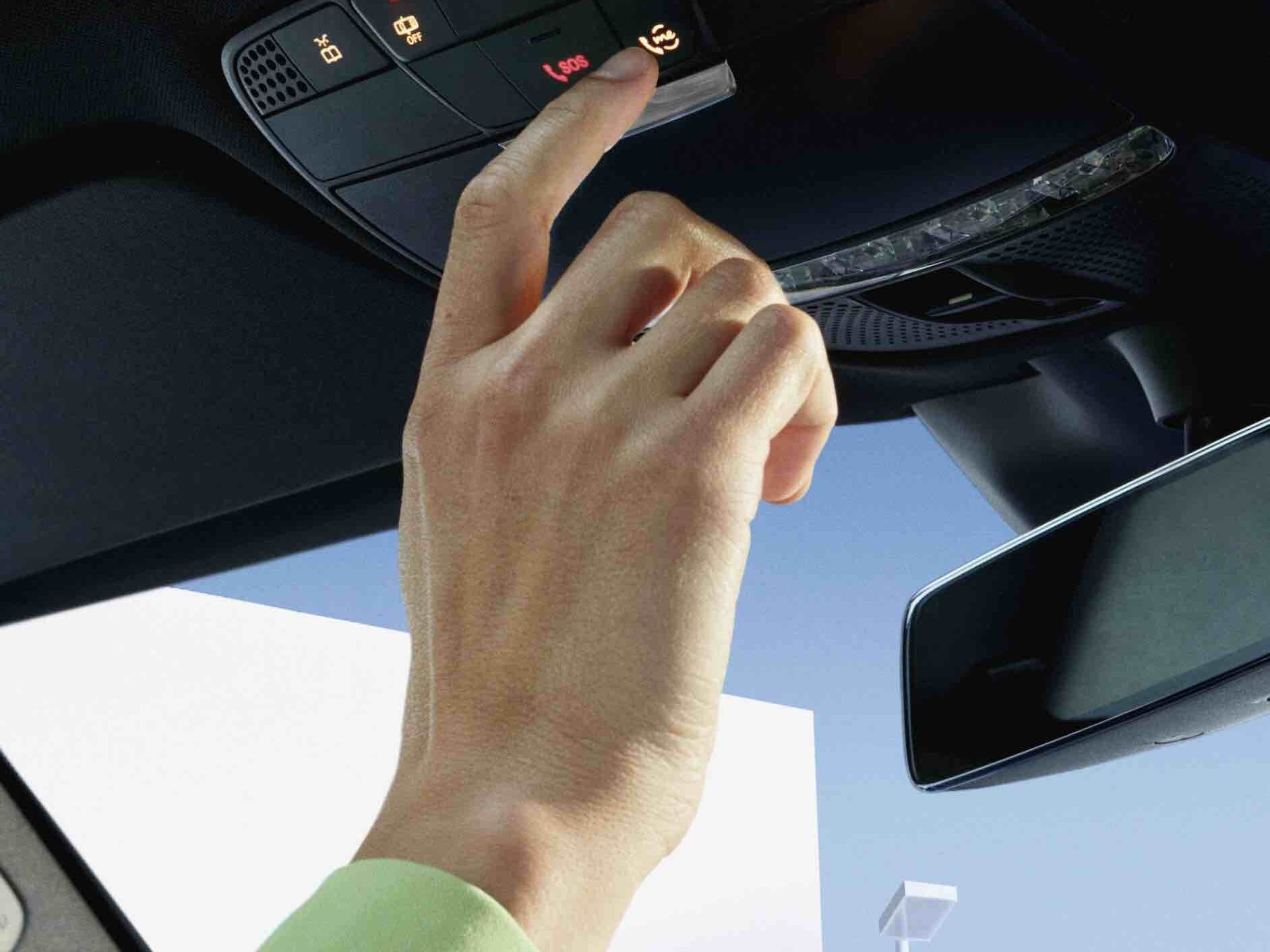 The Mercedes me button is pressed in the overhead control panel of a Mercedes-Benz.