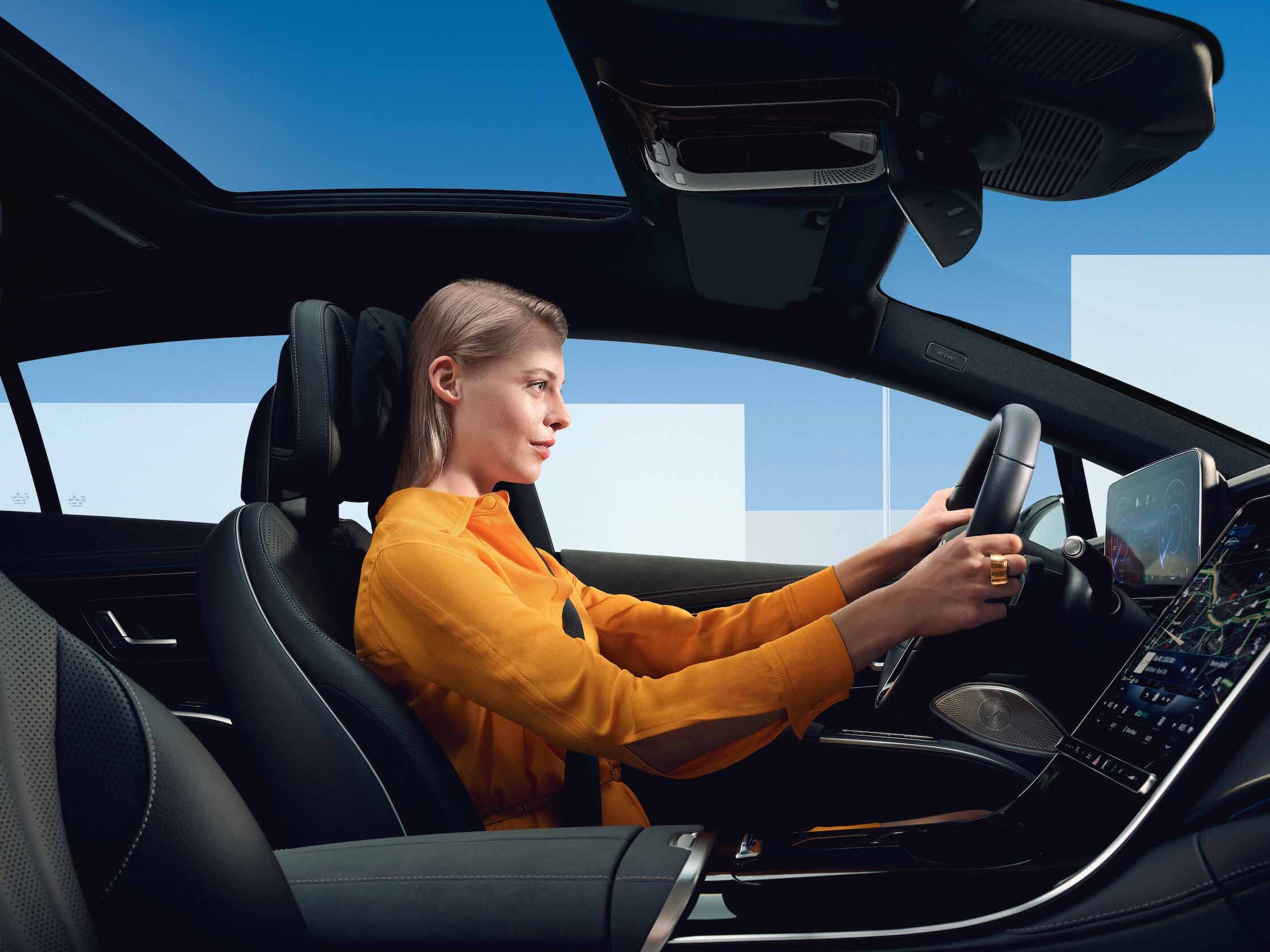 A woman at the steering wheel of her Mercedes Benz.