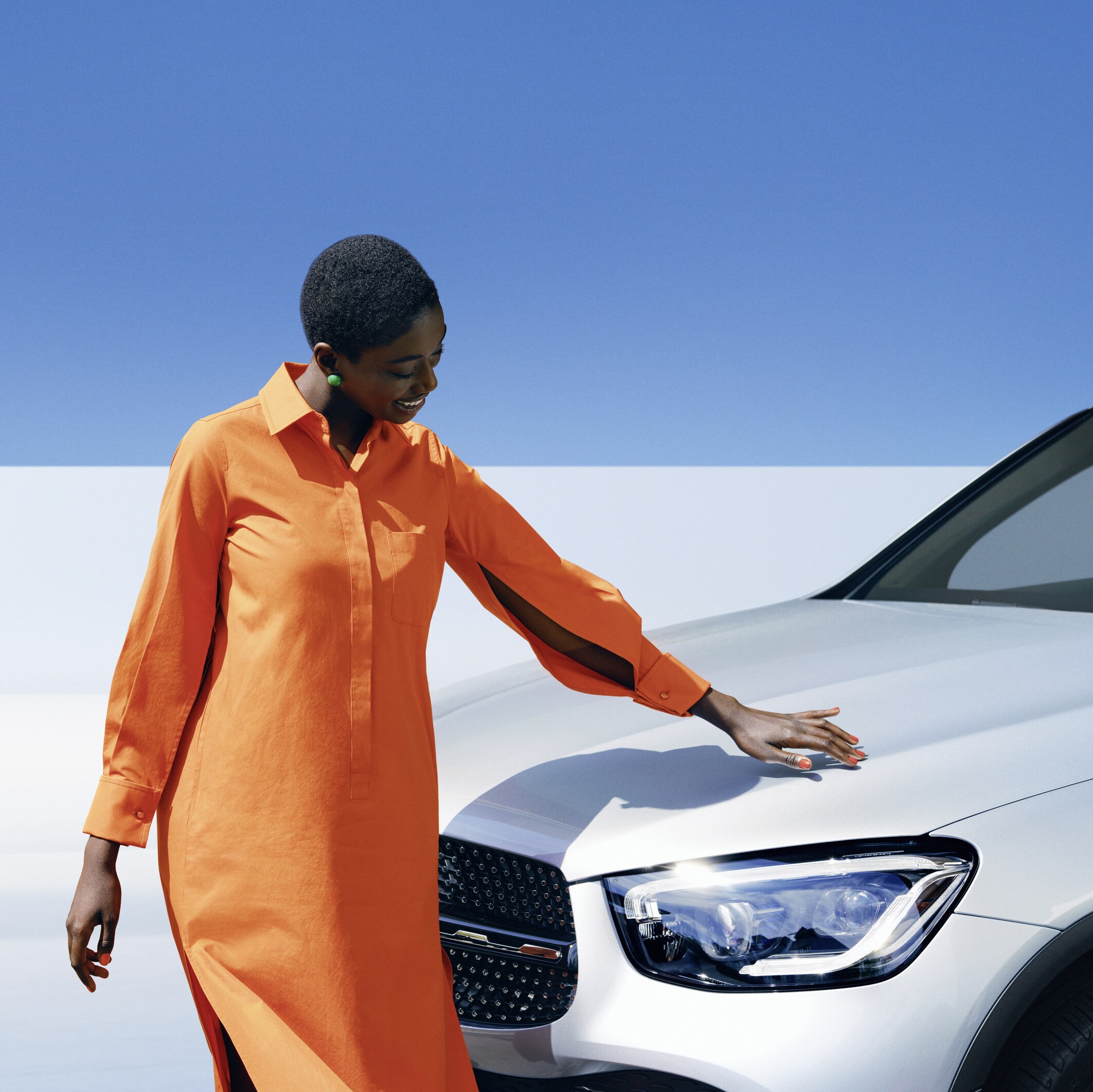 ผู้หญิงคนหนึ่งกำลังตรวจสอบรถยนต์ Mercedes-Benz ของเธอ