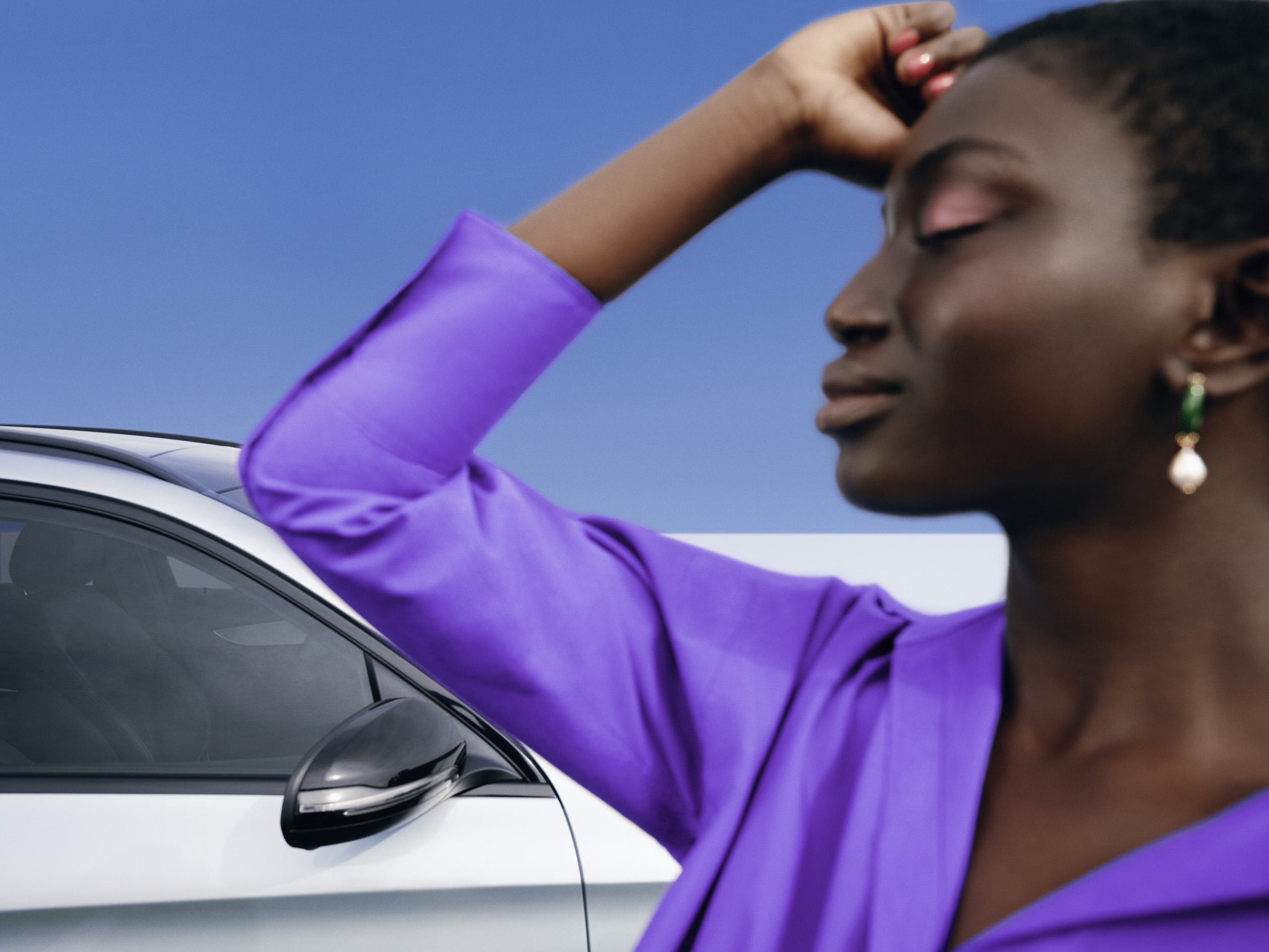 เริ่มต้นการเดินทางครั้งใหม่ด้วยความสดใส | ผลิตภัณฑ์ดูแลรักษาของแท้ | เมอร์เซเดส-เบนซ์ ผู้หญิงคนหนึ่งยืนอยู่ข้างหน้ารถยนต์ Mercedes ของเธออย่างผ่อนคลาย