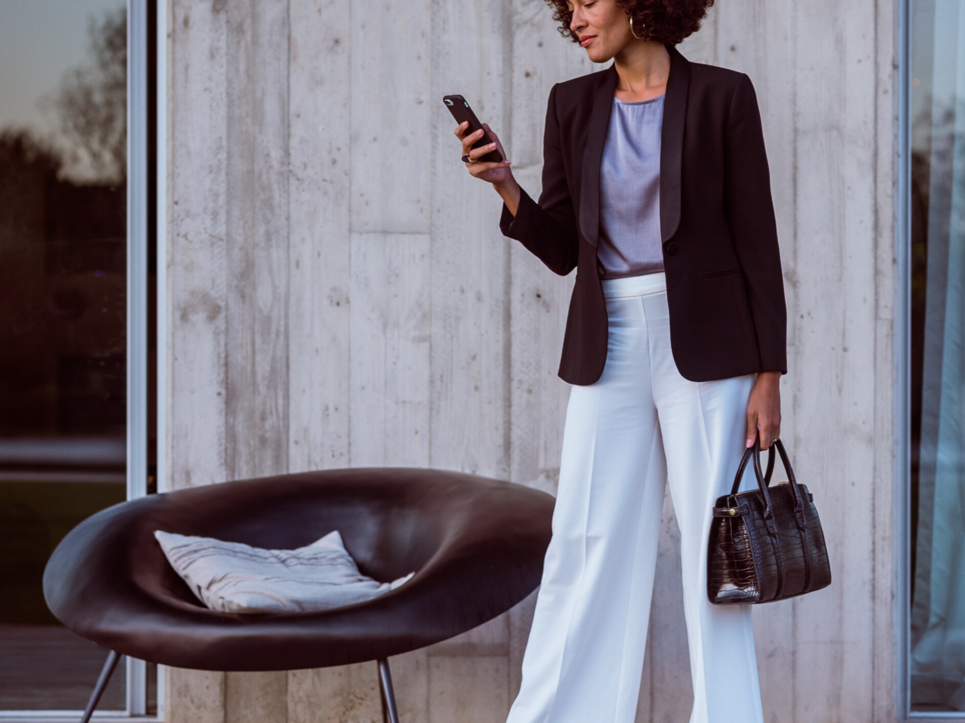 A woman connects to her Mercedes Benz via smartphone, the Mercedes Benz App and her Mercedes me ID.