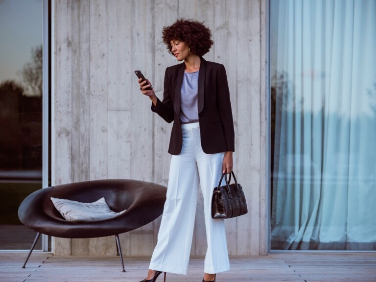 A woman connects to her Mercedes Benz via smartphone and the Mercedes me App and uses the Remote Digital Extras to check whether all the doors of her Mercedes-Benz are locked.