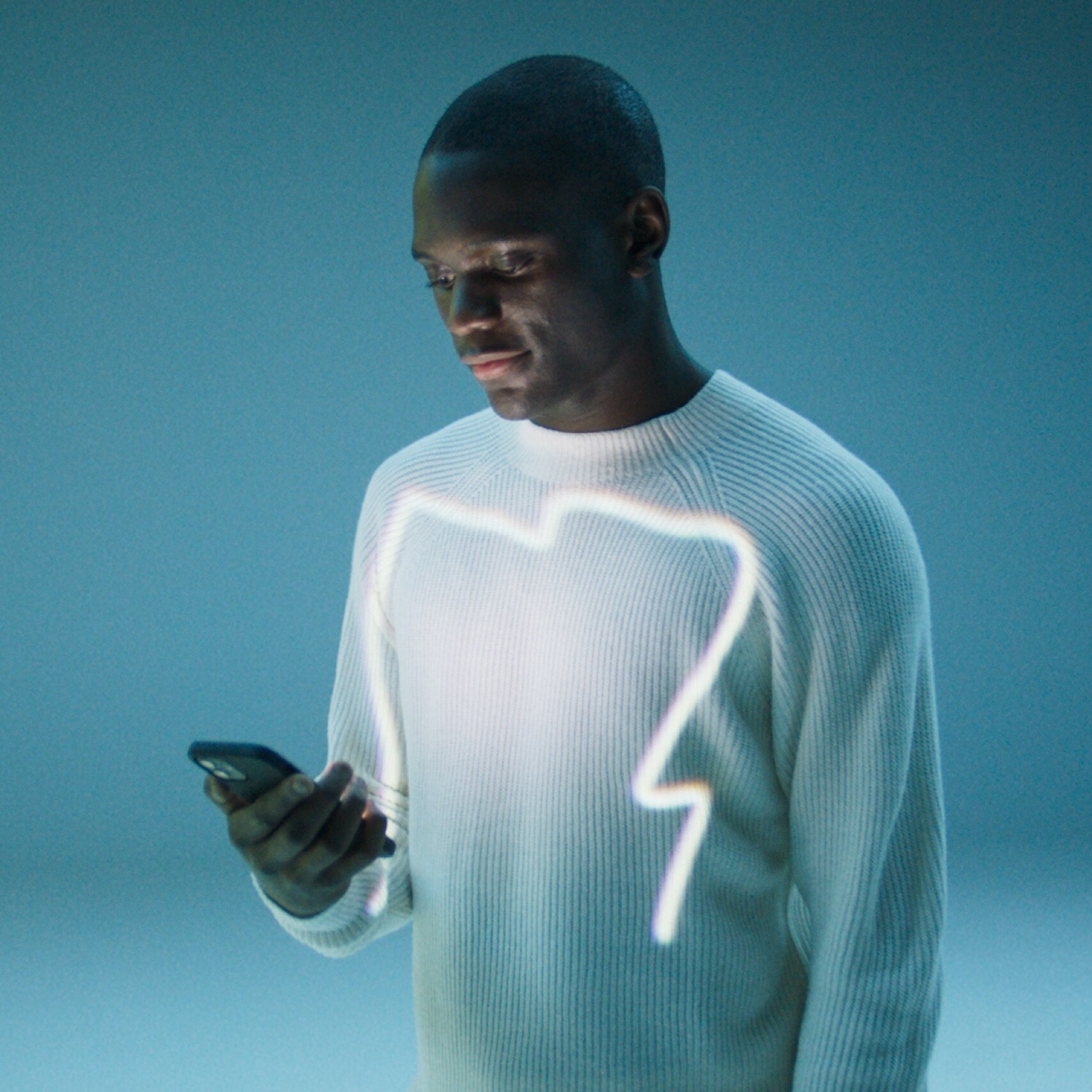 A man opens the Mercedes me App on his smartphone.