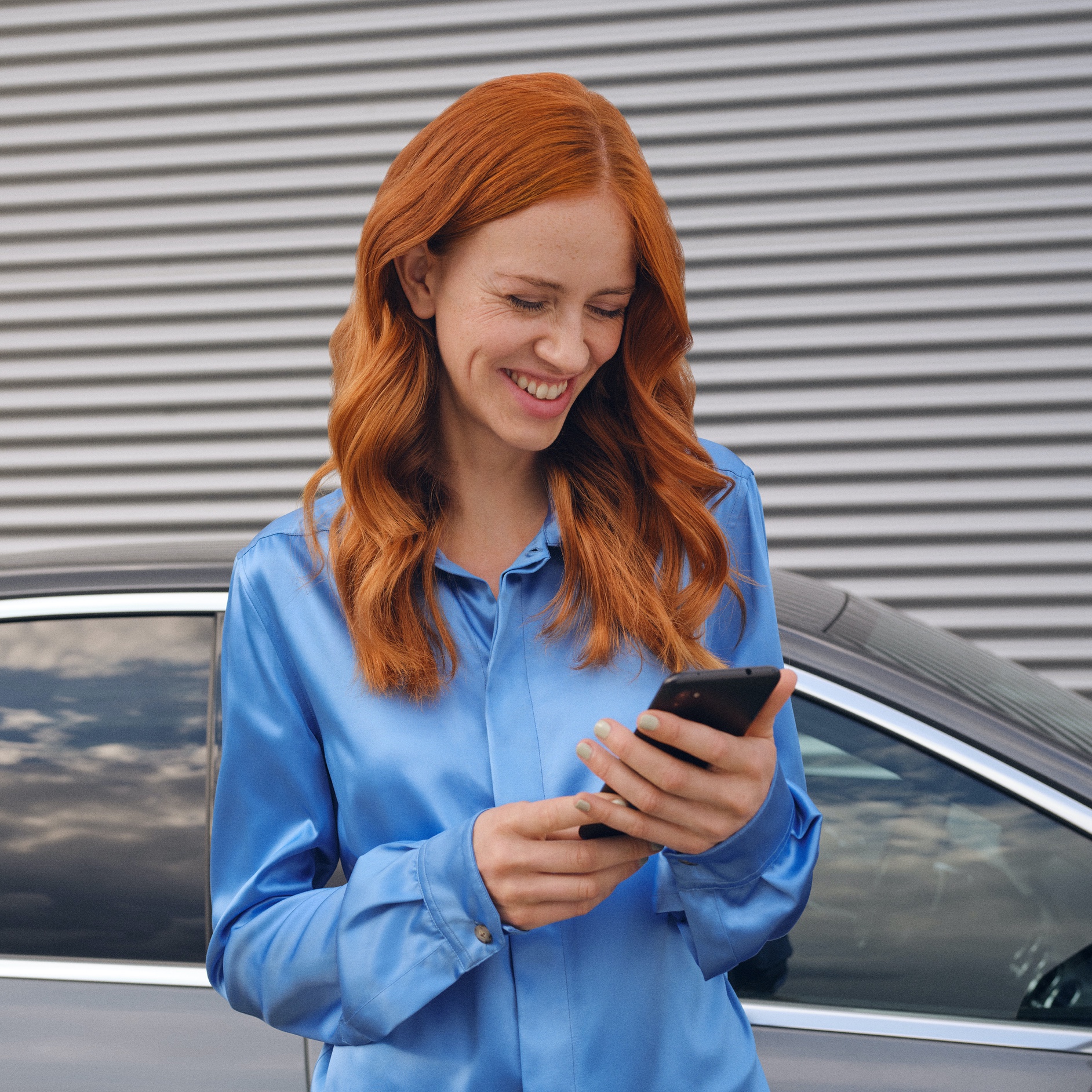 Use Digital Extras and Mercedes me App now | Mercedes me | Connect your car | Mercedes-Benz A woman connects to her Mercedes-Benz via the Mercedes me App on her smartphone.