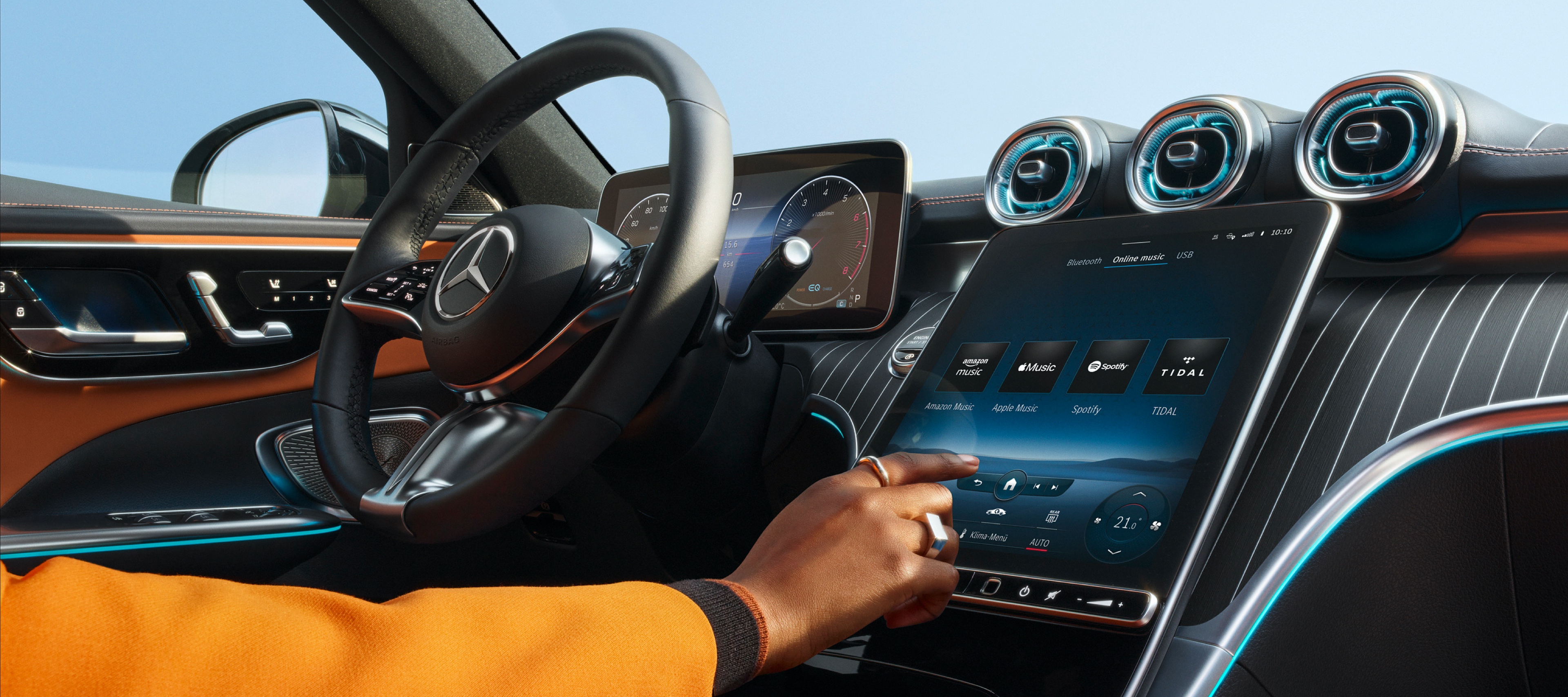 Entertainment | Mercedes me Person selecting the desired audio streaming service from Amazon Music, Apple Music, Spotify and TIDAL on the screen of the MBUX multimedia system in a Mercedes-Benz.