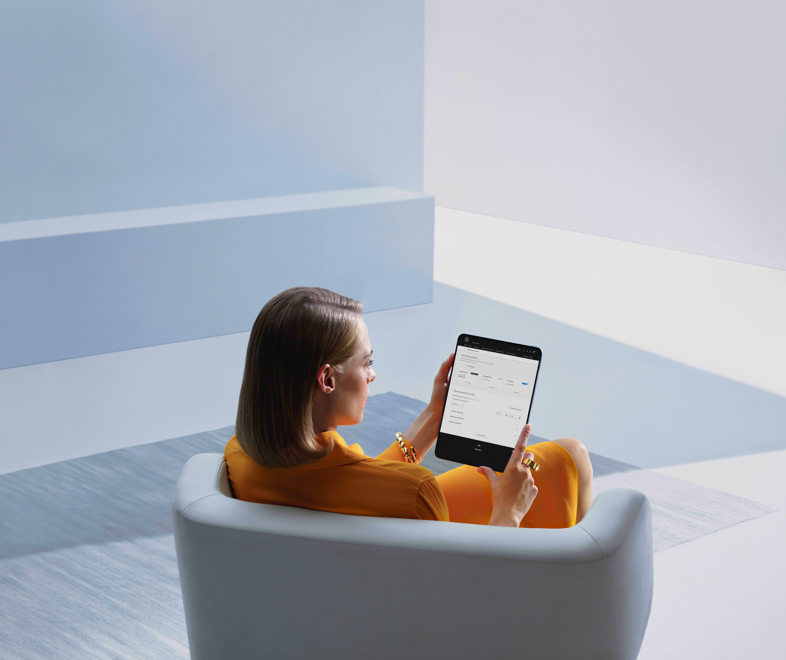 รายงานการเข้ารับบริการแบบดิจิตอล | บริการบำรุงรักษา | เมอร์เซเดส-เบนซ์ ผู้หญิงคนหนึ่งกำลังดูรายงานการเข้ารับบริการแบบดิจิทัลบนแท็บเล็ต