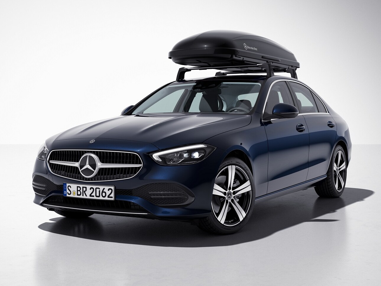 กล่องเก็บของบนหลังคา Mercedes-AMG สีดำติดตั้งอยู่บนหลังคารถยนต์ Mercedes-Benz สีน้ำเงิน