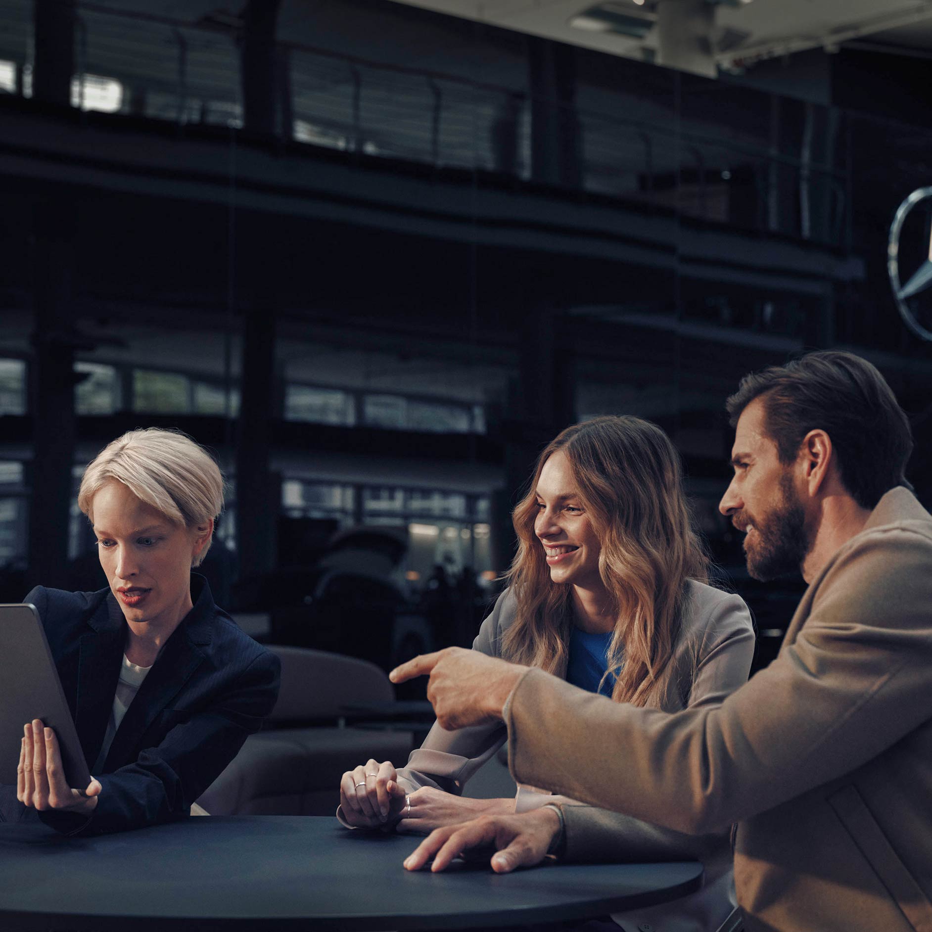 รถยนต์ใช้แล้ว | ลีสซิ่งและการจัดหาสินเชื่อ | Financial Services | Mercedes-Benz ผู้ชายและผู้หญิงนั่งโต๊ะร่วมกับตัวแทนจำหน่าย Mercedes-Benz