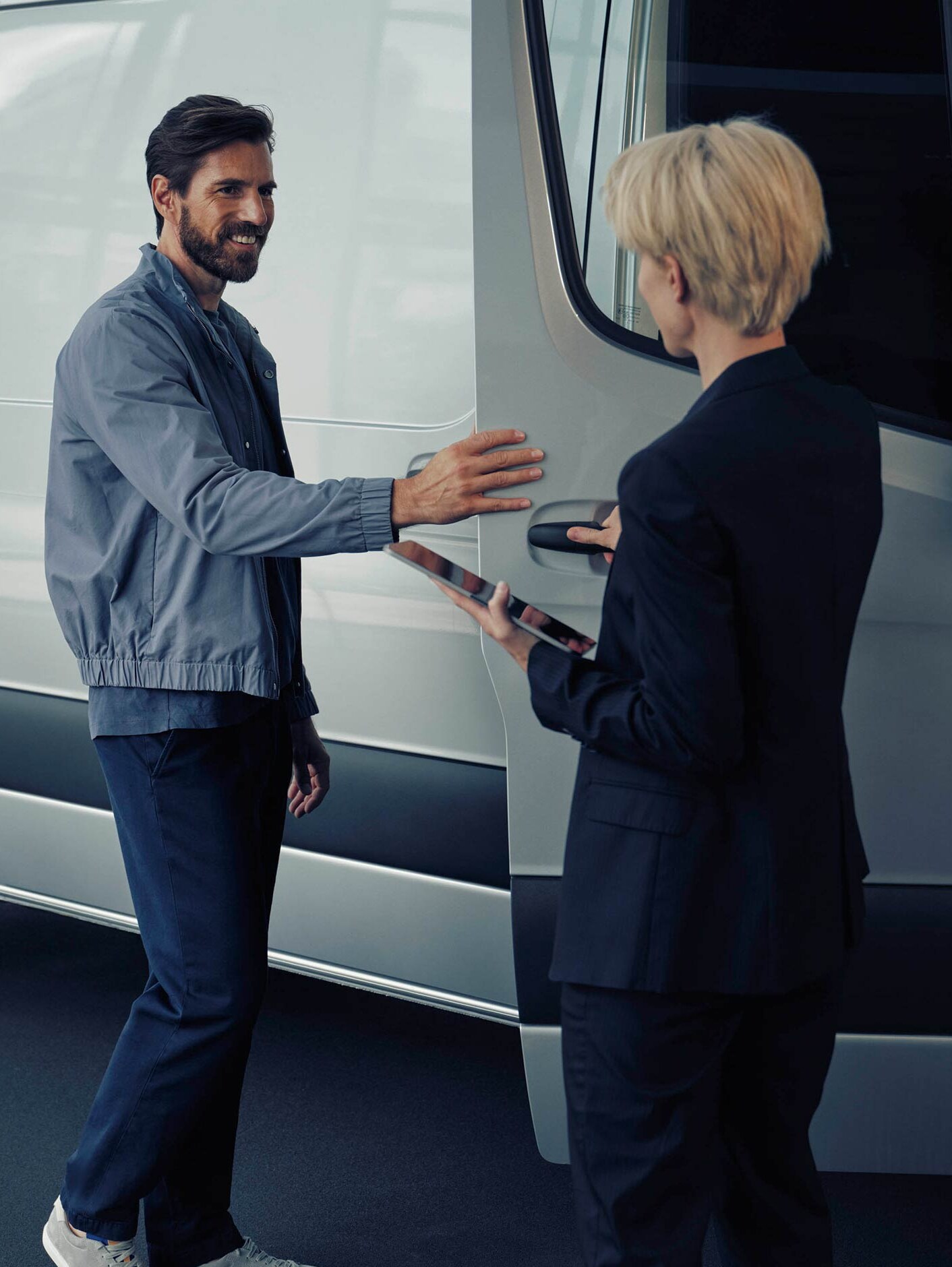 A man is talking to a Mercedes-Benz dealer about the white eSprinter van
