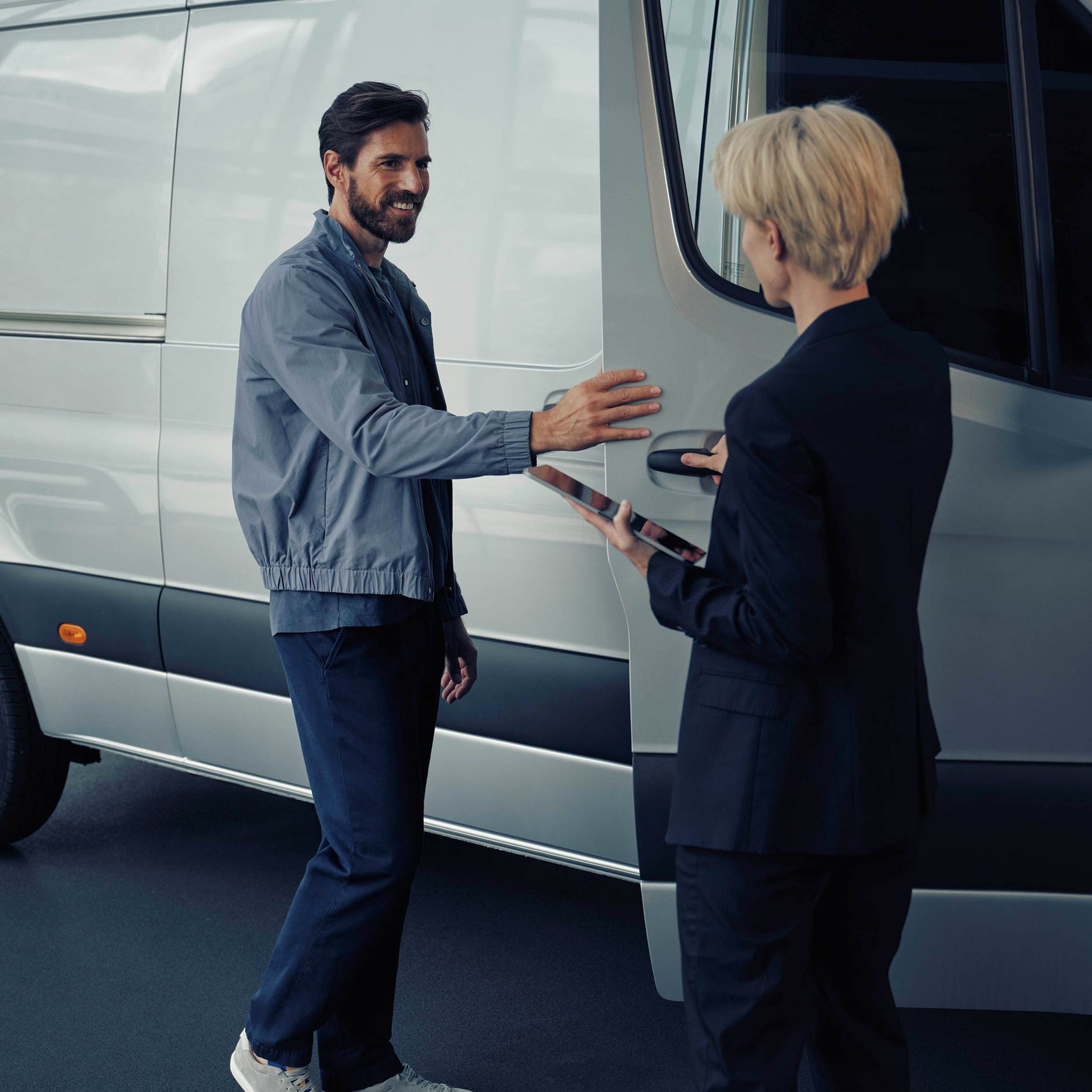 รถยนต์ใหม่ | ลีสซิ่งและการจัดหาสินเชื่อ | Financial Services | Mercedes-Benz ผู้ชายคุยกับตัวแทนจำหน่าย Mercedes-Benz เกี่ยวกับรถตู้ eSprinter สีขาว