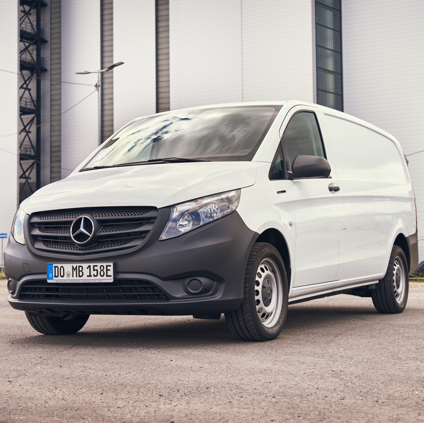 A white eVito panel van from Mercedes-Benz parked on an industrial site.