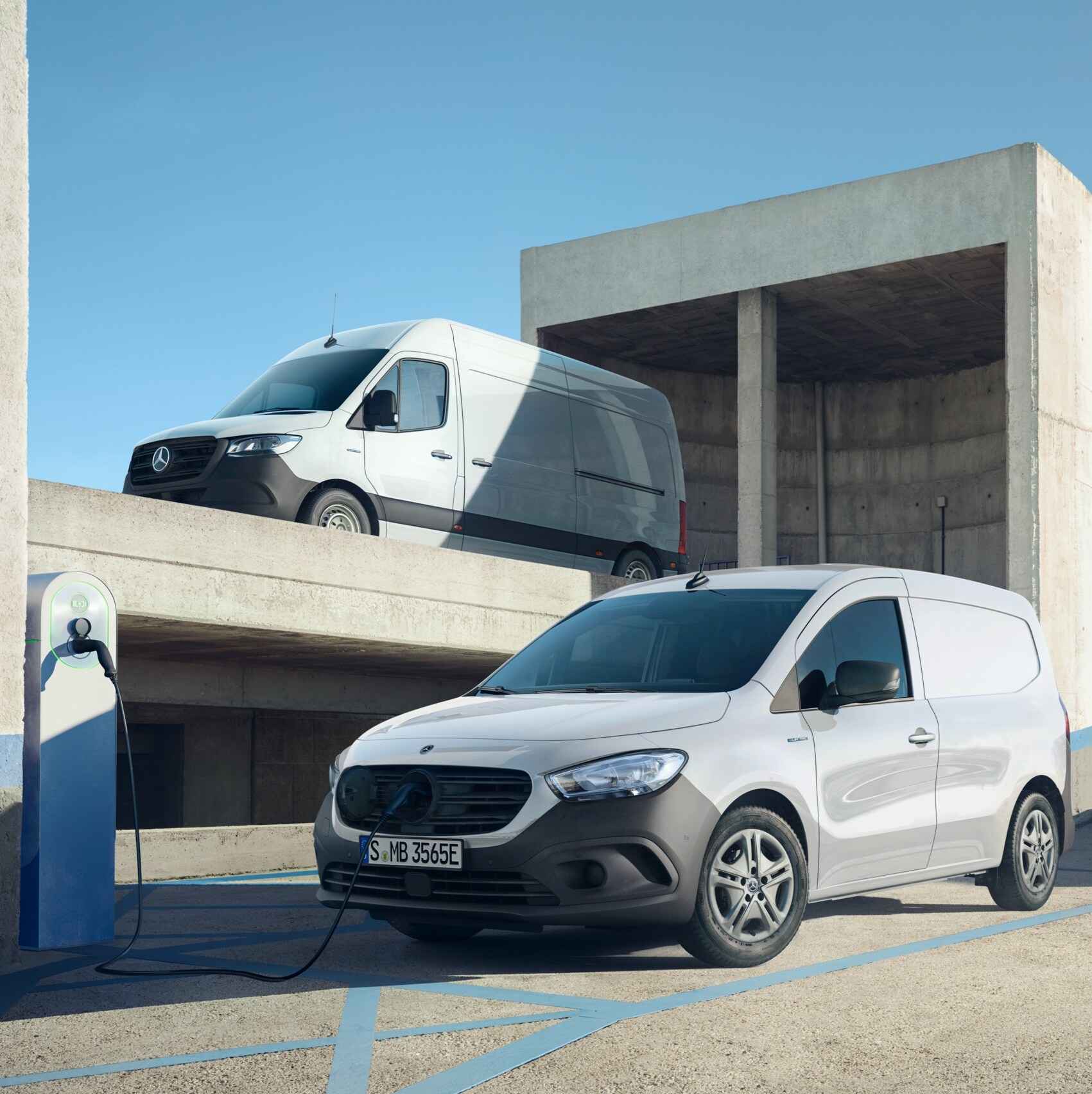 The eSprinter, eVito and eCitan, electric vans from Mercedes-Benz, stand together in an urban environment.