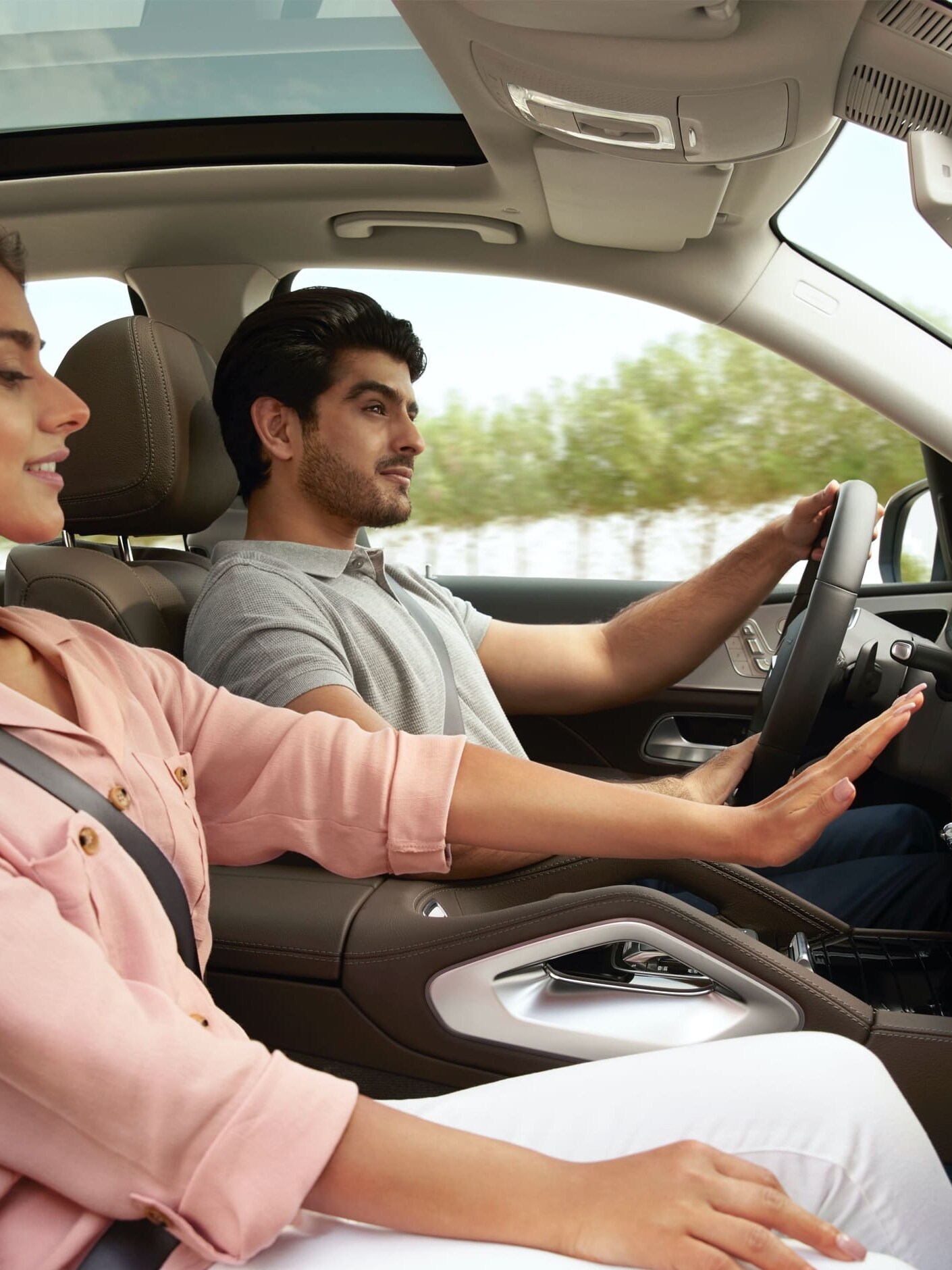 ผู้หญิงคนหนึ่งยกมือขึ้นที่หน้าช่องแอร์ใน Mercedes-Benz ของตนเอง