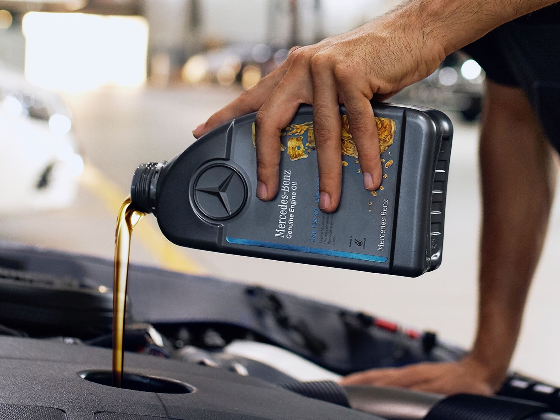 ผู้เชี่ยวชาญด้านเทคนิคจาก Mercedes-Benz กำลังเติมน้ำมันเครื่องแท้