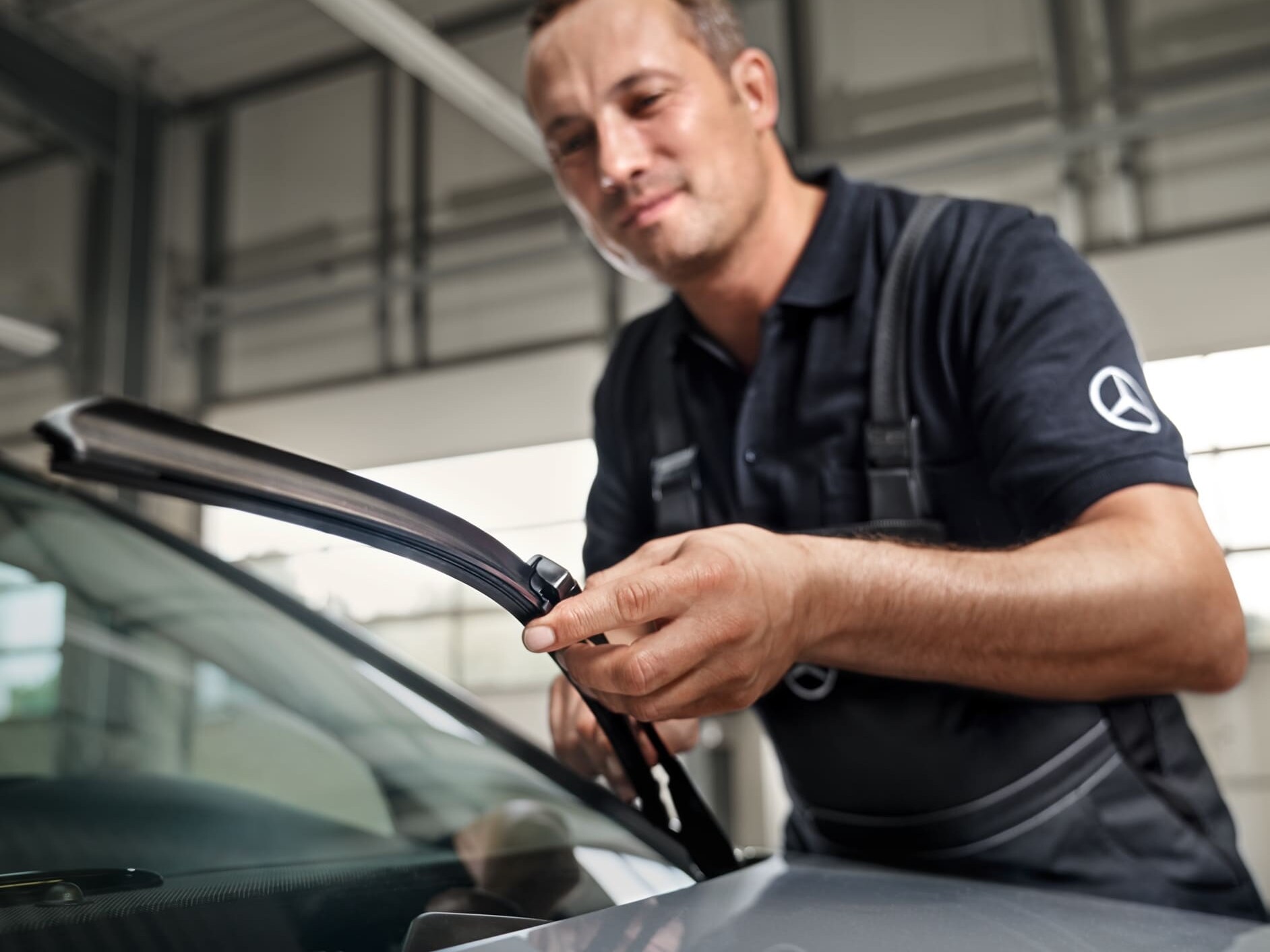 A Mercedes-Benz technician changes the windscreen wipers on the vehicle.