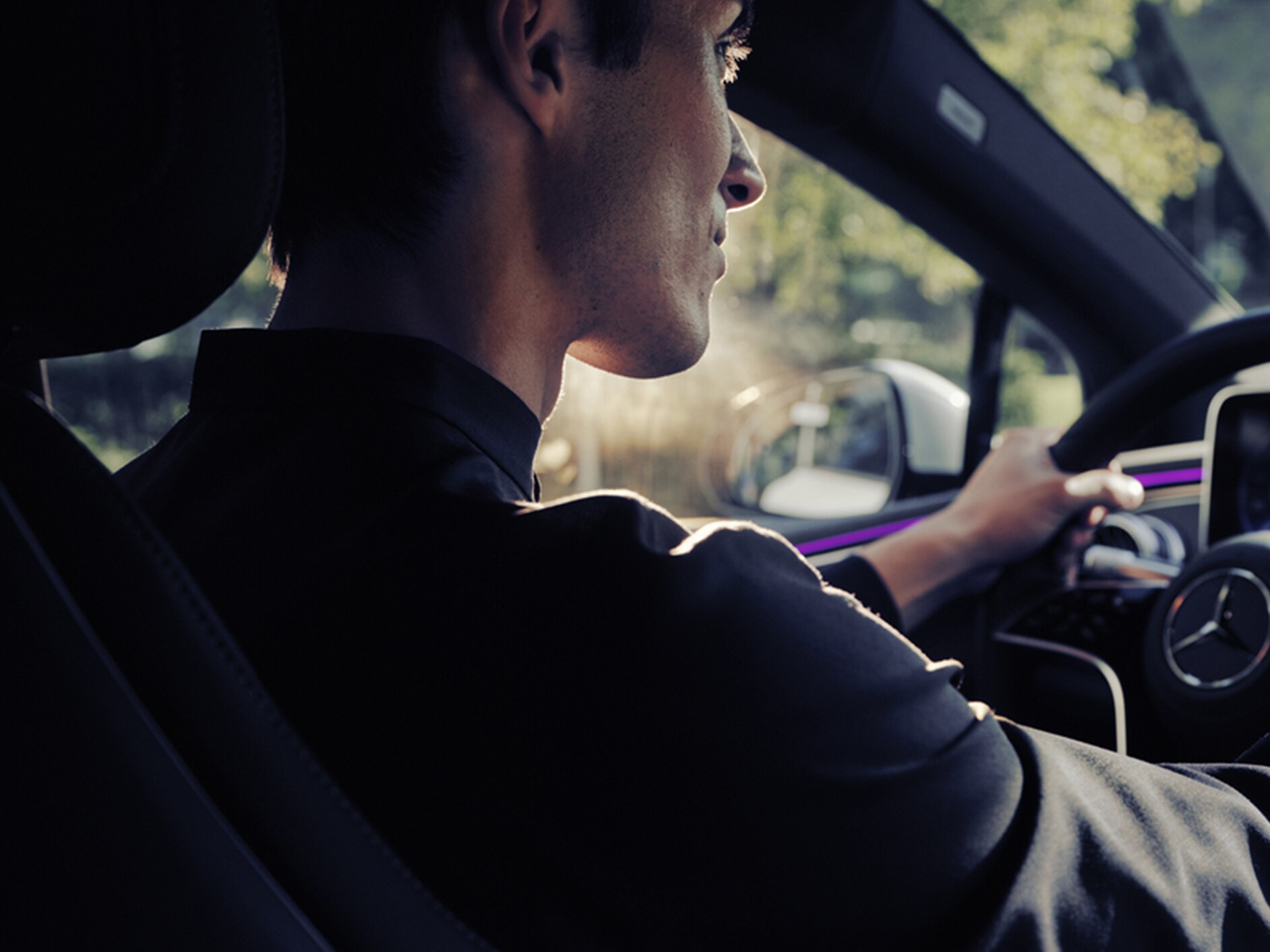 ผู้ชายกำลังขับรถยนต์เมอร์เซเดส-เบนซ์